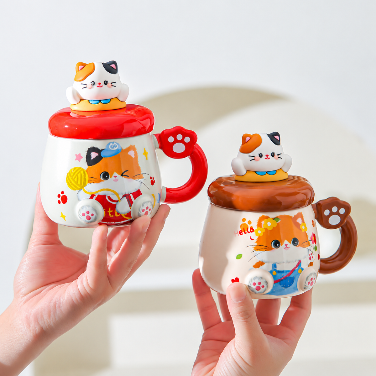 Red and brown ceramic cat mugs with sculpted kitty lids and paw-accent handles.