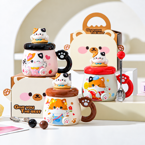 Three ceramic cat mug colors displayed with matching spoons and gift packaging.