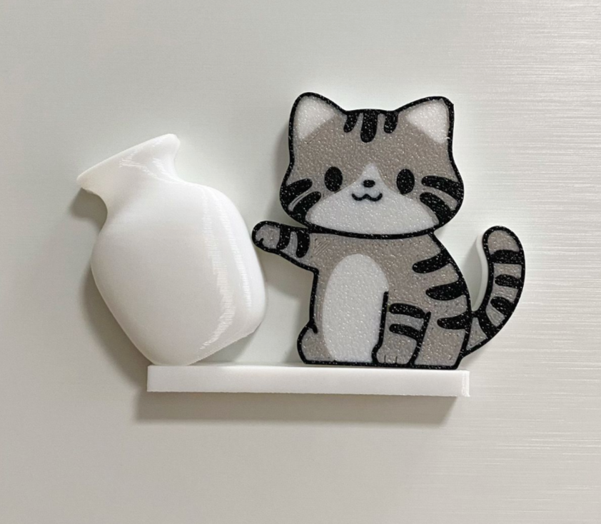 Gray Tabby acrylic refrigerator magnet with white tilted vase, approximately 6 cm long