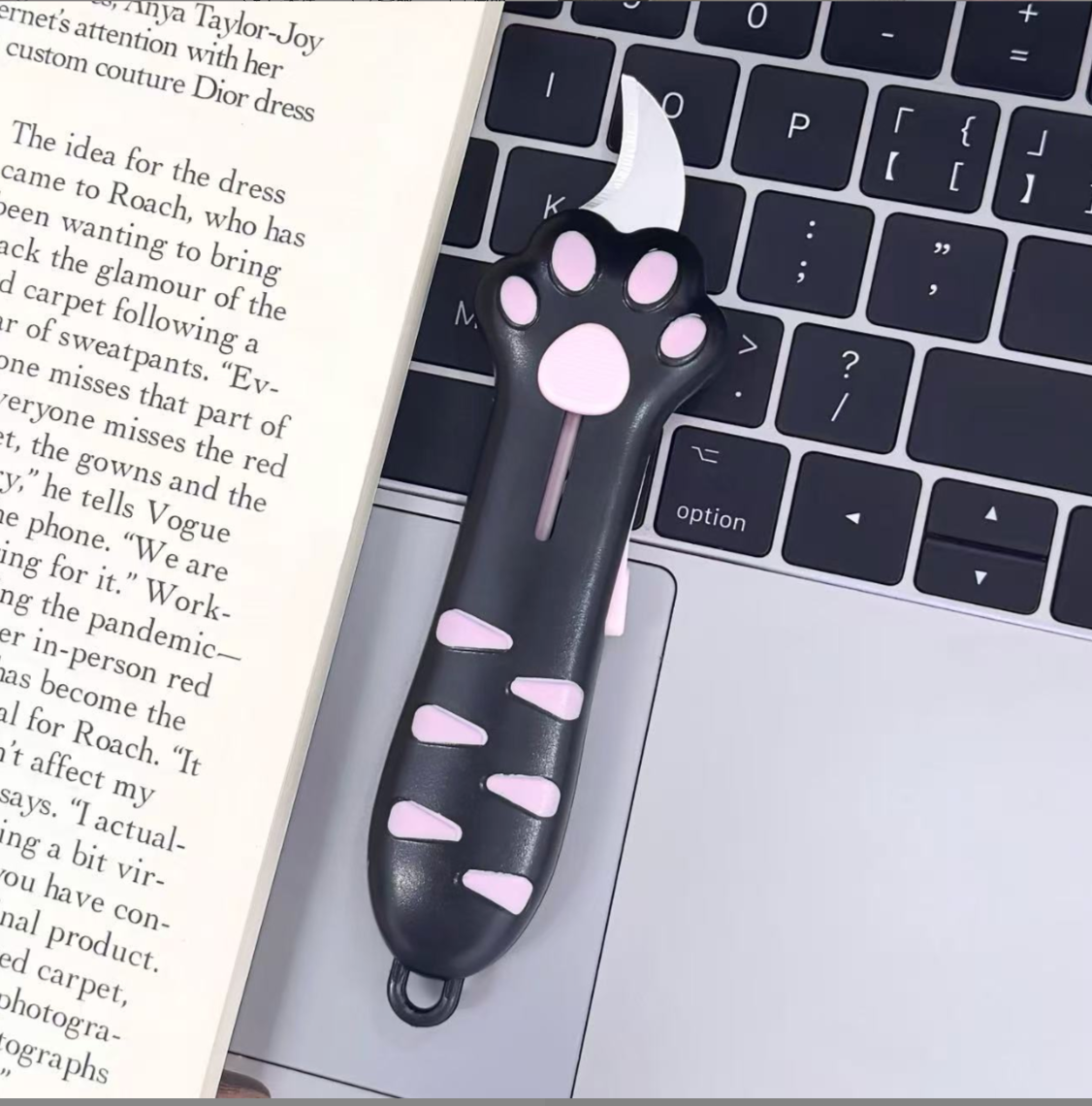 Black / Pink cat paw retractable box cutter with pink paw pads and a curved stainless steel blade.