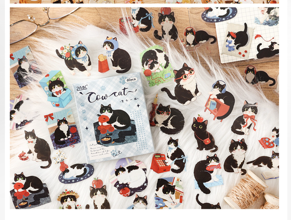 Cow Cat black-and-white watercolor cat stickers with a blue-gray plaid box.